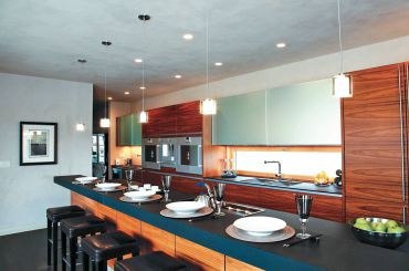 The kitchen in this photograph combines recessed can lights, pendant lights and under-cabinet lighting, providing layers of lighting that can be added or subtracted at a flip of a switch. (Photo courtesy Stone Lighting Design)