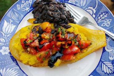 Stuffed zucchini with polenta, bruschetta, balsamic glaze and black beans