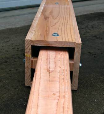 View into the bat's entrance at the base of the rocket box. Bolts anchor the box to the inner post and wood spacers maintain the proper 3/4-inch distance between the box and post. Notice that the 4-by-4 that the box itself is mounted on is untreated lumber to protect bats from toxins.