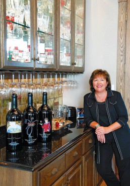 Moore with three of her "Make the DASH Count" label wines; at far right is The Innkeeper Cabernet Sauvignon, named to honor her mother.