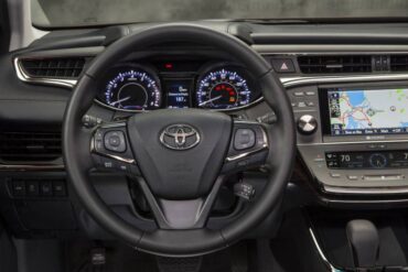 A thick, contoured leather steering wheel has very good auxiliary controls. This is a non-hybrid dash as noted by the tachometer.