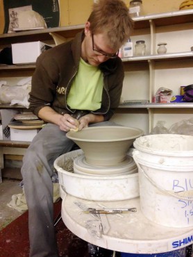 Jordan Meyer, whose work will be displayed at one of the tour studios, works at his potter's wheel.