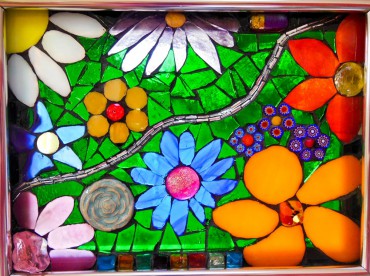 Exuberant window hanging designed with mirrored glass and ceramic flowers to reflect interior light and stained glass and millefiori beads to glow with backlight