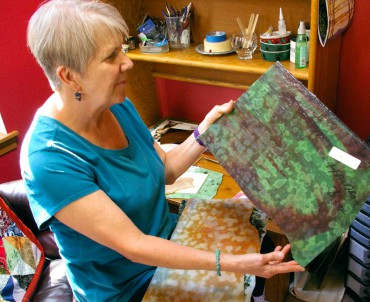 Louise Martin admires sheets of Uroboros handmade art glass given to her by stained-glass artist Haldean Windsor.