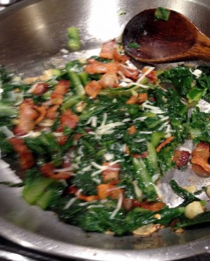 Skillet of ready to serve sautéed dandelion greens with bacon