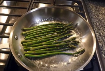 Asparagus simmering in shallow skillet