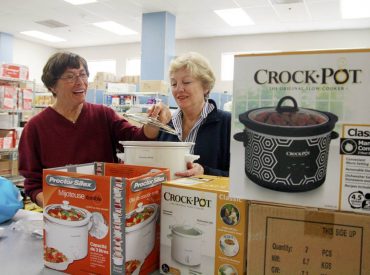 At Key Peninsula Middle School's assembly point, from left, Karen Jorgenson and Key Peninsula Lions Club member Cindy Robison are sorting crockpots for the Food Backpacks 4 Kids program. Jorgenson initiated the crockpots addition to the program in 2014, and the KP Lions contributed over 30 of them. (Photo courtesy Hugh McMillan)