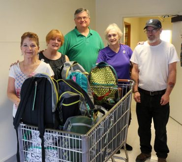 The Bremerton crew with a donated Costco cart of fun backpacks