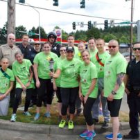 Runners and support personnel pause in East Bremerton during the Flame of Hope hand-off from the joint running team of the Kitsap County Sheriff's Office/Kitsap County Prosecuting Attorney's Office to Bremerton Police Department during the 2016 Law Enforcement Torch Run.