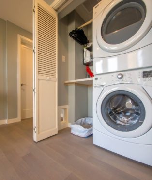 A simple closet gets a maxium laundry makeover, complete with cat door and litter box, folding table and drying rack.