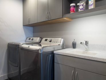 Set high to clear the washer door, these laundry room wall cabinets were made deep for accessibility.