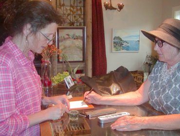 Eve Laeger, right, asks owner Annabella Serra for help with her fountain pen.