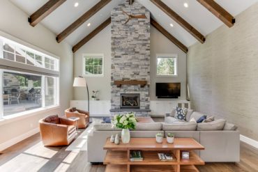 Great room grass cloth muted color scheme and textured stone fireplace (Photo by Matthew Witschonke)