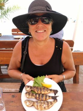 Laureen Lund enjoying grilled fish at a beachside café Burgas.