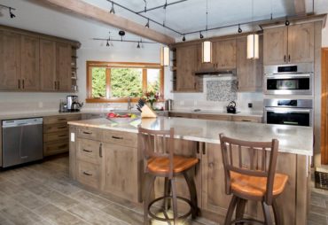 On trend "distressed wood" plank porcelain floor tiles complement the rustic cabinetry.