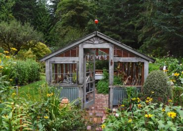 The greenhouse is the center of attention among beds of cutting flowers.