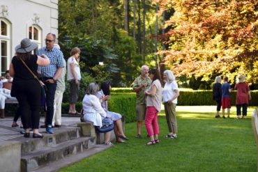 Visitors to the residence at Bloedel enjoy an art show "Inspired by Bloedel" and a sunny evening with a view of Puget Sound.