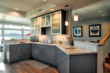 On-trend, contemporary, grey-textured laminate base cabinets combined with aluminum wall cabinet doors with frosted glass