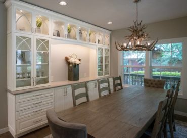 Off-white painted cabinets with mullioned doors and raised panel drawers