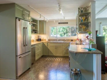 Trending, green-painted cabinets with customized open shelves for personalized decorative options