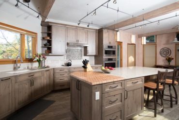 Crown molding and light valance with a complimentary profile gives this rustic kitchen a tailored look.