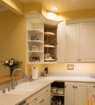 Trending, painted raised-panel -oak cabinets with corner-optimizing convenience hardware