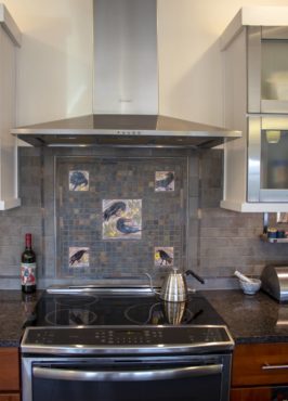 Artist Patti McQuillin made the crow tiles for the kitchen backsplash above the cooktop.