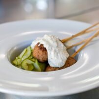 Greek lamb kofta; spiced and grilled lamb kebabs, served with tzatziki sauce and a marinated cucumber salad