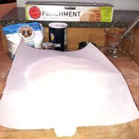 6) Place parchment paper over dough.
