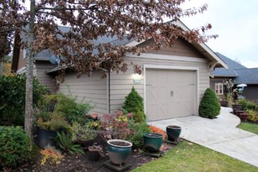 Carriage-style garage doors, vintage-style lighting and Arts & Crafts-style address numbers add authenticity to this Craftsman-style home in Poulsbo. (Photo courtesy Richard Walker)