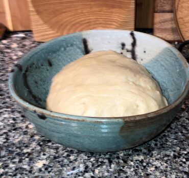 Dough in buttered bowl