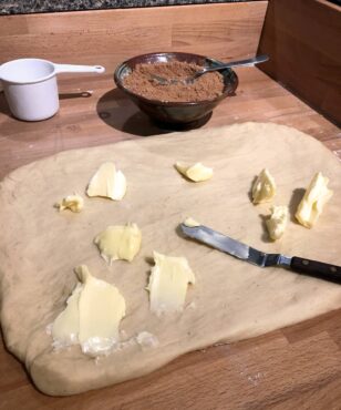 Spread soft butter onto dough.