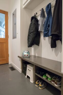 Built-in bench and coat hooks provide an organized landing space for coats, shoes, etc. (Photo courtesy A Kitchen That Works LLC)