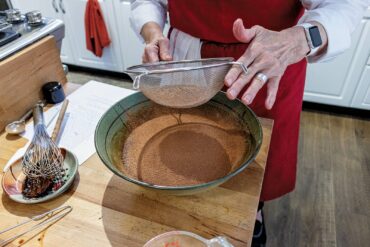 Sift cocoa powder into chocolate-egg mixture.