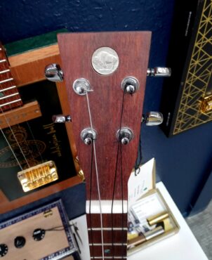 Buffalo nickel set into headstock of instrument