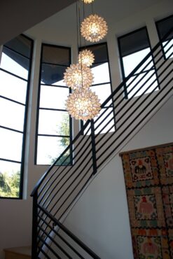 A chandelier of spheres made of translucent shells formed into flowers hangs in the stairway.