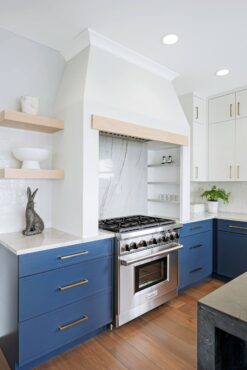 Kitchen featuring blue cabinetry and island and custom-designed hood (Photo courtesy Matthew Witschonke)