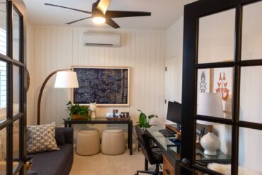 Home office with shiplap walls and black doors