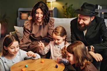 Jewish family playing traditional dreidel game