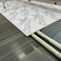 Final stage of porcelain slab production — the graphics are created in Photoshop and transferred to an ink jet printer to apply the glaze. After the glaze is fired, a quality-control sensor scans the slab.