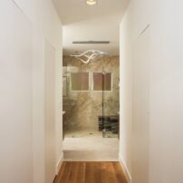 View of bathroom from bedroom (closets with concealed doors on either side)