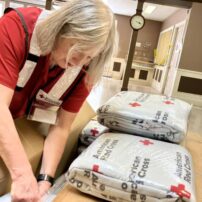 Red Cross volunteer Kerri Foley sorts items for individuals impacted by a recent fire in Lakewood.