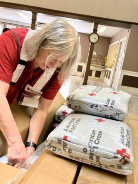 Red Cross volunteer Kerri Foley sorts items for individuals impacted by a recent fire in Lakewood.