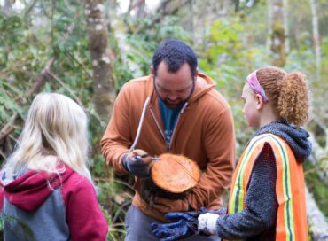 Great Peninsula Conservancy Executive Director Nate Daniel explaining tree rings with Land Labs students