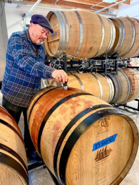 Fletcher Bay Winery owner and head winemaker Jim Wilford pulling a barrel sample of his wine