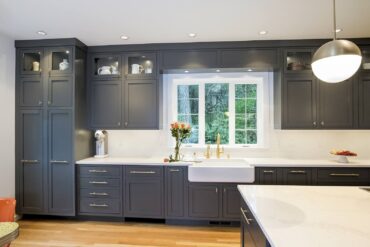Contemporary farmhouse kitchen with pendant, display, recessed pods and undercabinet lights. Design by McCabe By Design LLC