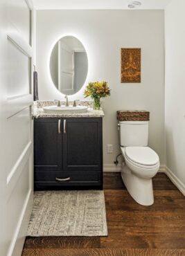 A powder room backlit LED mirror provides perfect all around illumination for guests. Design by McCabe By Design LLC (Photography courtesy Tammy Dwight)