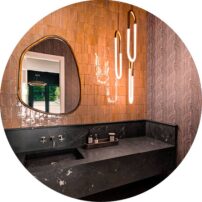 THE “POW”DER ROOM There’s nothing like bold wallpaper in a small space. This Mitchell Black Loft Collection Woven Arcs paper in cocoa brown is perfection with Cle Zellige Vesper Sands tile.